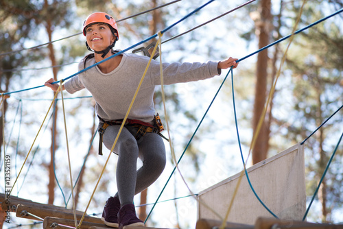 Behang Happy enthusiastic woman having great time in the adventure park