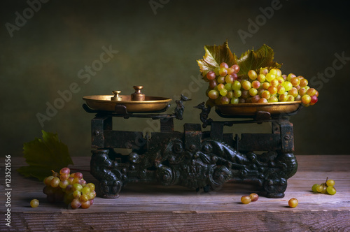 Still life with grapes on old vintage scale. photo