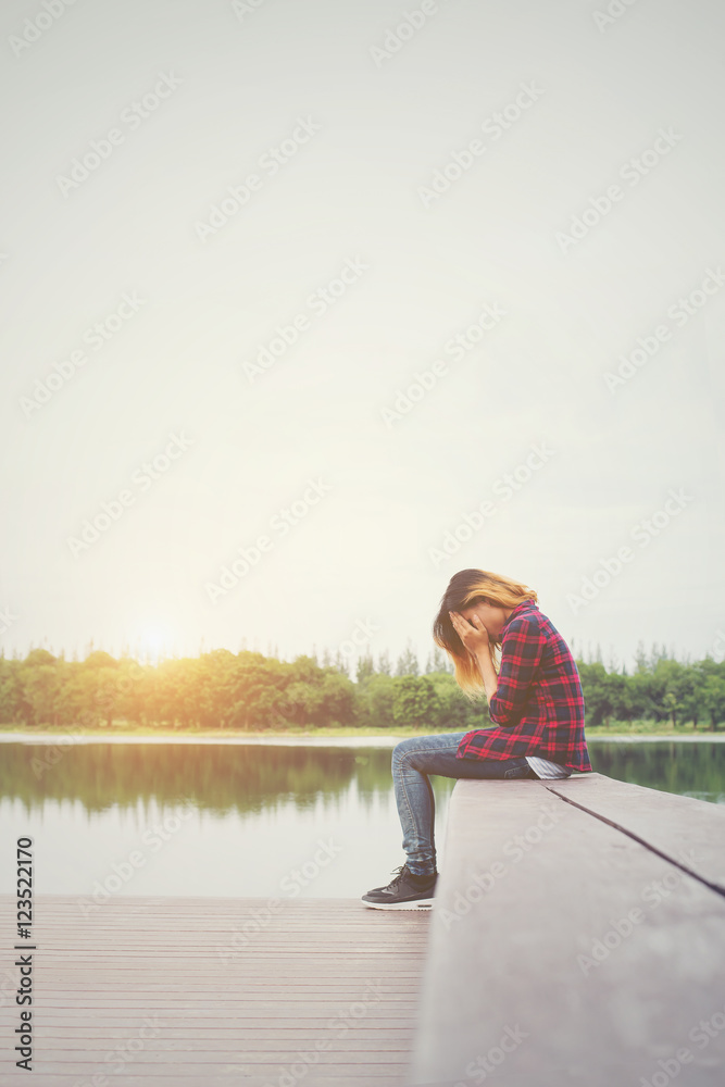 Sad hipster woman sitting on the pier with sadness. Sad hipster woman sitting on the pier with sadness.
