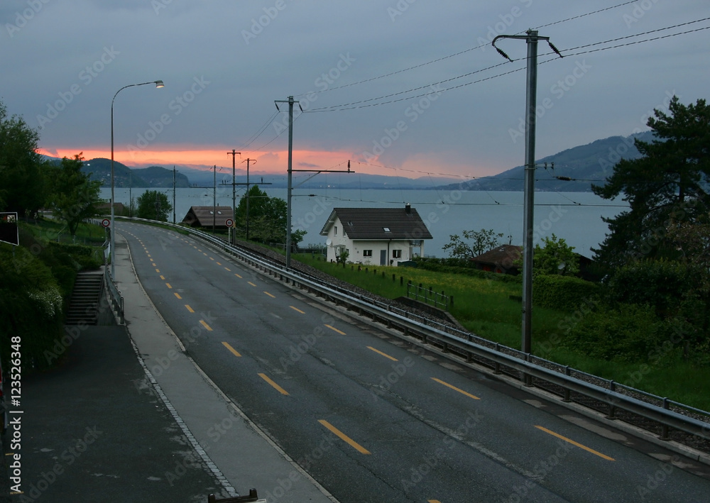 Road with lake and mountains in the background in Switzerland Road with lake and mountains in the background in Switzerland
