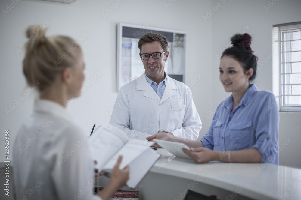 Man in white coat meeting with woman at company reception area Man in white coat meeting with woman at company reception area