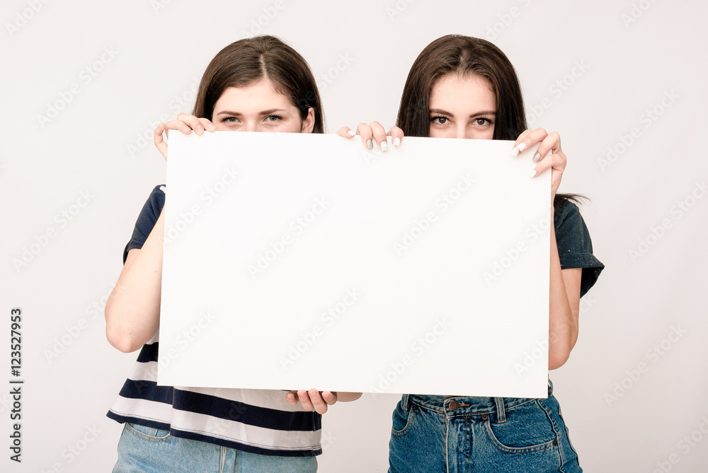 Two happy smiling young women carring big blank signboard Two happy smiling young women carring big blank signboard