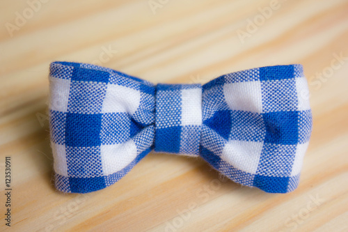 Blue and white bow or tie on wooden background