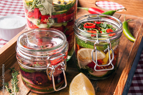 fermentiertes Gemüse in Gläsern auf Holzbrett