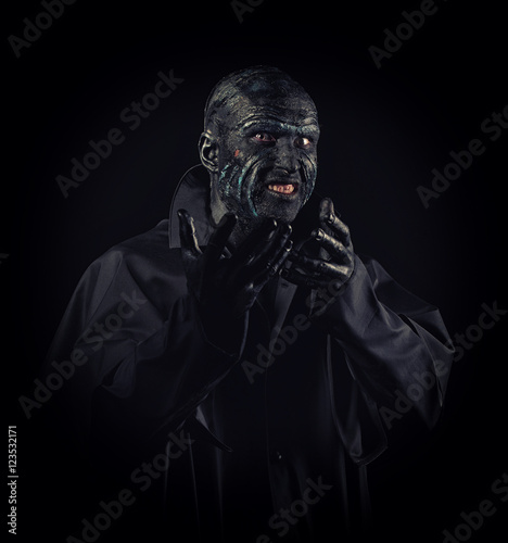 Studio portrait of a man in monster makeup, dark background