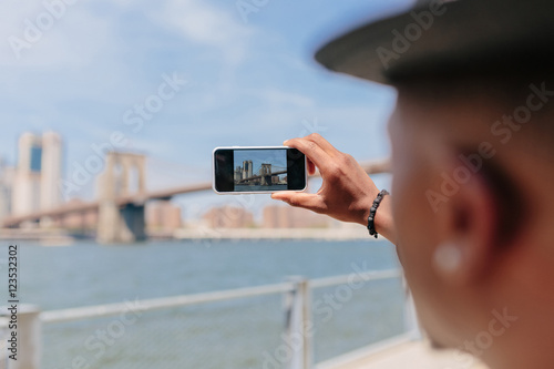 Young Fashionable Guy Taking Picture of the Manhattan Skyline . New York City photo