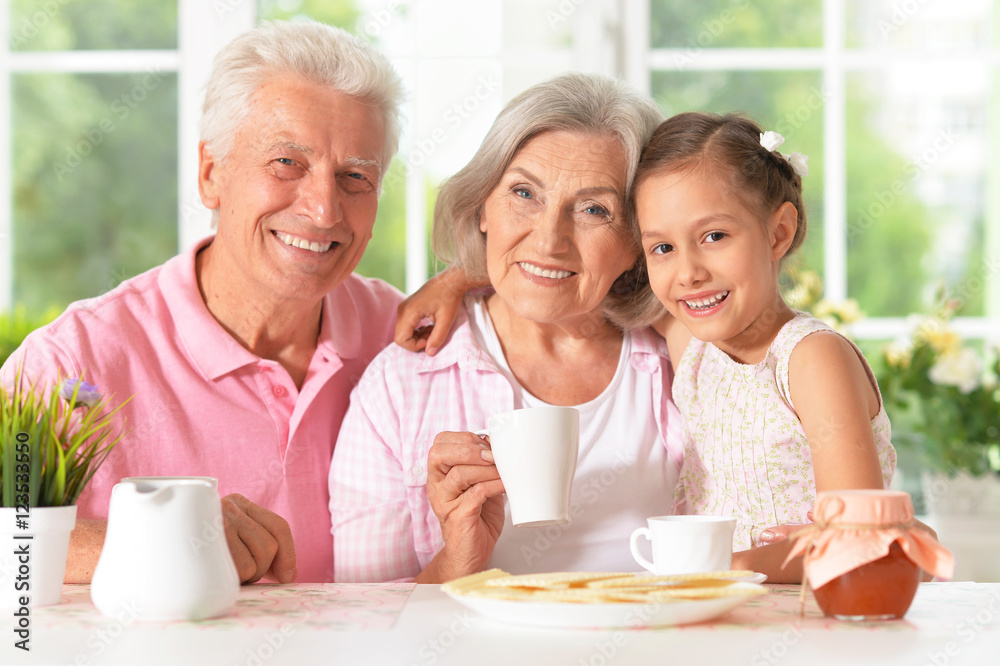 grandparents with granddaughter drinking tea grandparents with granddaughter drinking tea