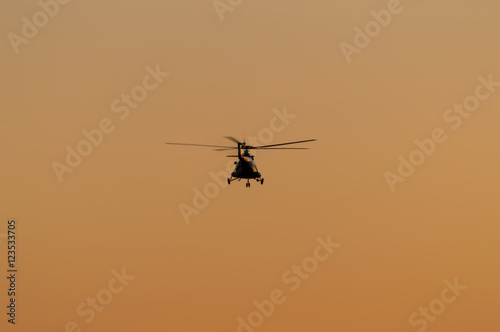 Silhouette of helicopter with sunset sky