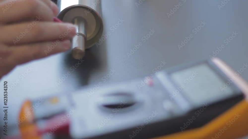 Technician using electronic measuring device Technician using electronic measuring device