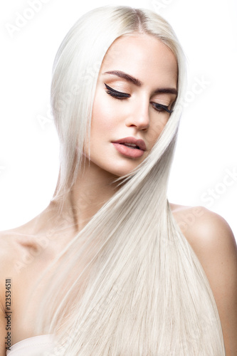 Obraz Piękna blond dziewczyna w ruchu z idealnie gładkimi włosami i klasycznym makijażem. Piękna twarz. Zdjęcie zrobione w studio.