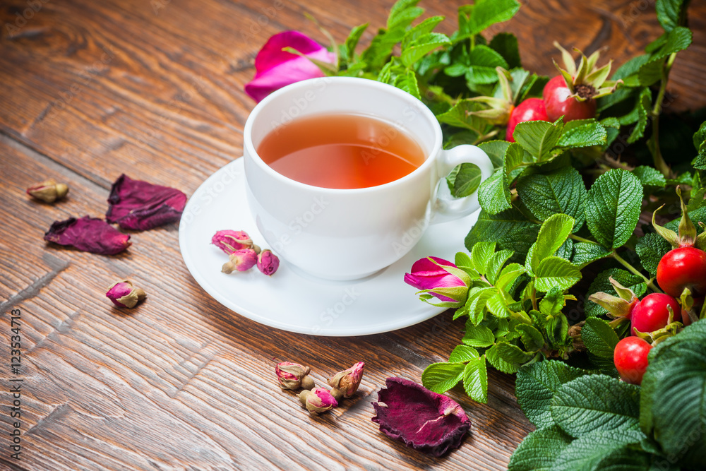 Healthy tea with a dogrose on wooden table Healthy tea with a dogrose on wooden table