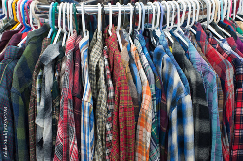 Thrift store flannel shirts on a clothing rack