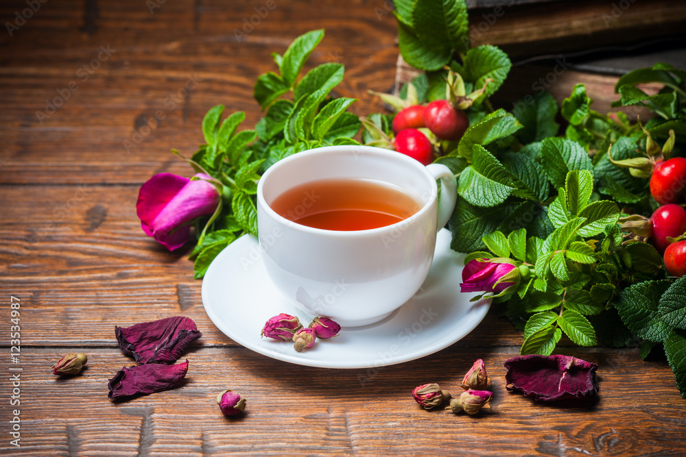 Healthy tea with a dogrose on wooden table Healthy tea with a dogrose on wooden table