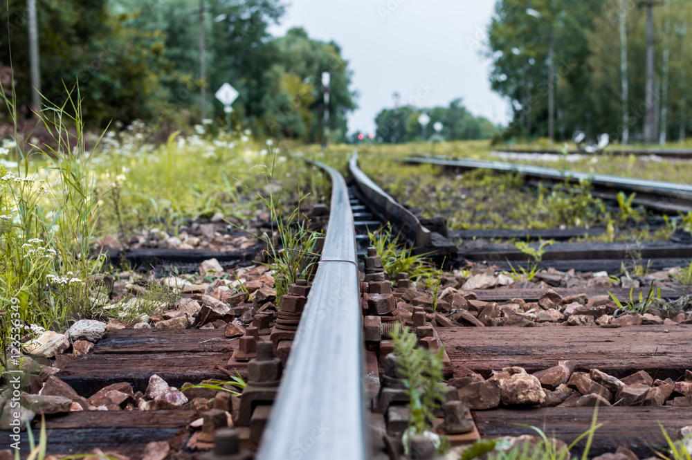 Old railway tracks and gravel leading into the infinite distance with selective focus Old railway tracks and gravel leading into the infinite distance with selective focus