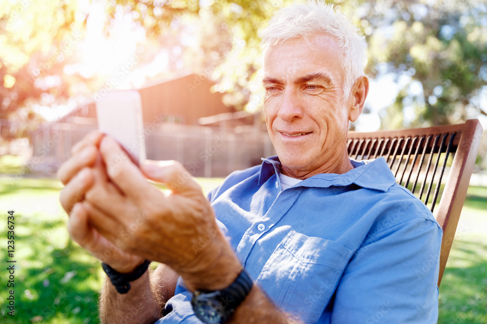 LoMature man outdoors using mobile phone LoMature man outdoors using mobile phone