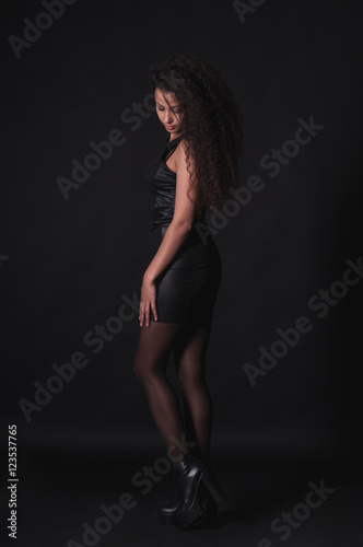 Pretty woman with long curly hair on dark background