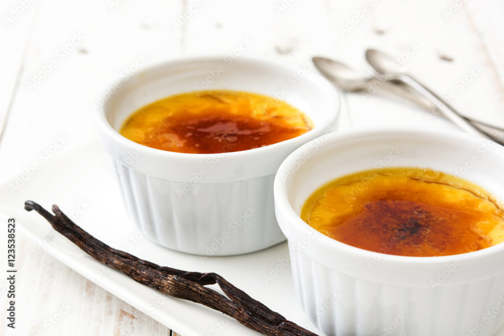 Traditional French creme brulee dessert with caramelized sugar on top, on wooden table
Traditional French creme brulee dessert with caramelized sugar on top, on wooden table