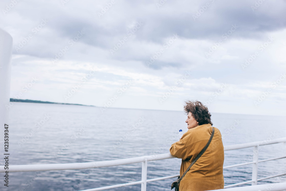 woman on a ferry looking into the sea distance