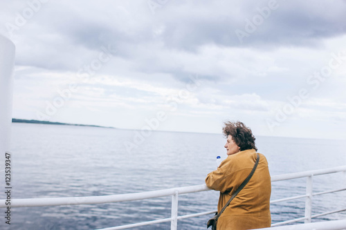 woman on a ferry looking into the sea distance