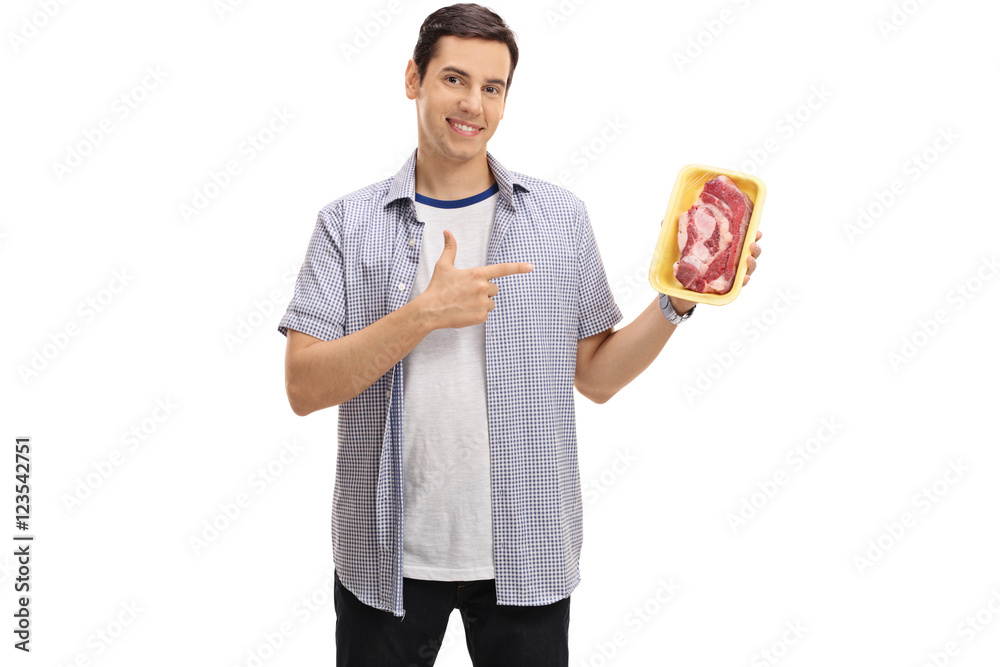Cheerful guy holding a steak and pointing Cheerful guy holding a steak and pointing