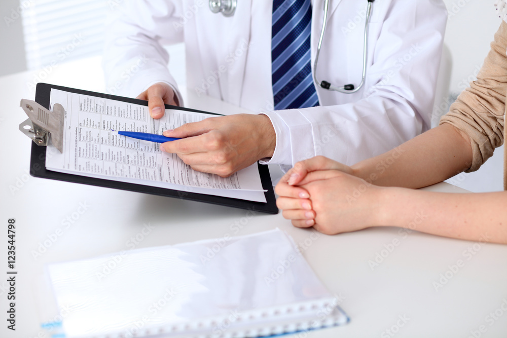 Fototapeta premium Close-up of a doctor man holding application form while consulting patient