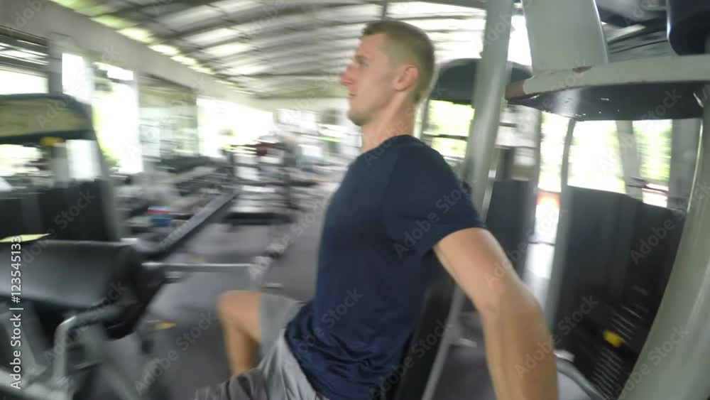 Strong Athletic Man Training in Gym on Fitness Machine. 4K Strong Athletic Man Training in Gym on Fitness Machine. 4K