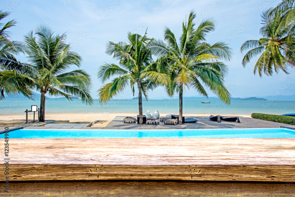 wood terrace over blue sea and tropical island beach background.
