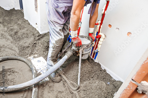 Employee performs sand and cement screed floor. Sand and cement floor screed