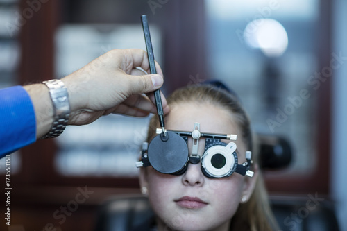 Girl doing eye test at optometrist's photo