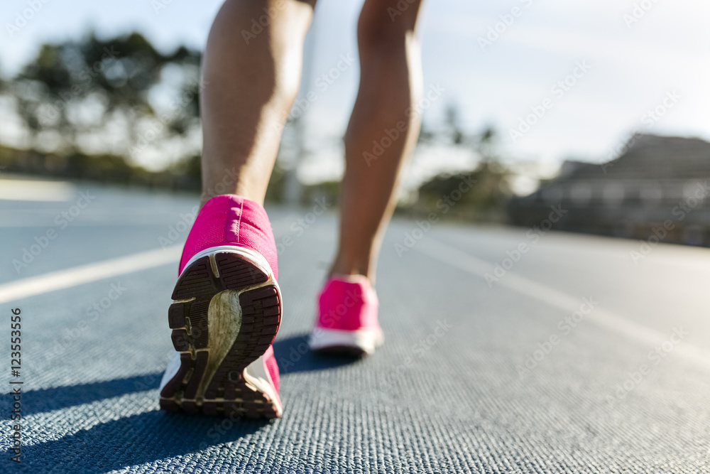 Legs of female athlete running on racetrack Legs of female athlete running on racetrack