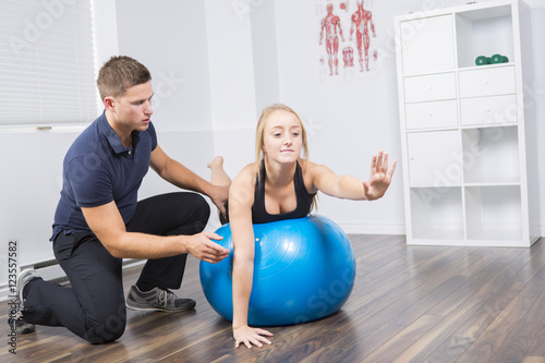 male physio therapist and woman helping patient