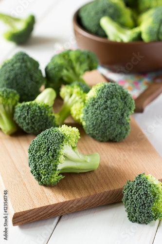 Fresh broccoli scattered on wooden table.
