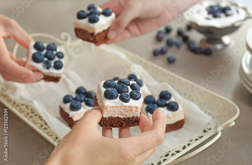 Female hands holding blueberry cakes, closeup