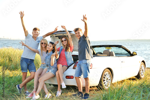 Happy friends near car