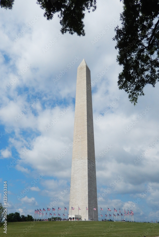 The Washington Monument obelisk landmark against a cloudy sky on the National Mall in Washington DC, USA.