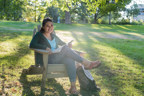 College girl studying under a tree in the park