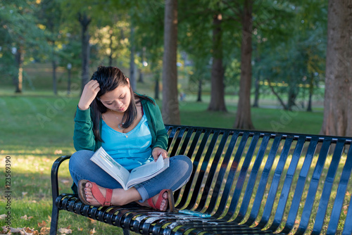 Female college student studying on a bench