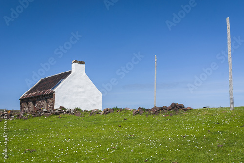 This is the Clachtoll Bothy, a small basic croft, where the salmon fishermen used to live while the salmon season was on. It also shows the poles they used to hang the nets on to dry. photo