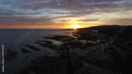 Aerial reveal from lighthouse with a green flashing light. photo