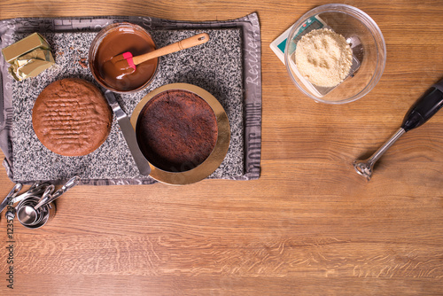 chocolate cake on kitchen table with kitchenware, top view