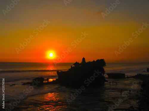 Tanah Lot and sea waves in golden sunset, Bali