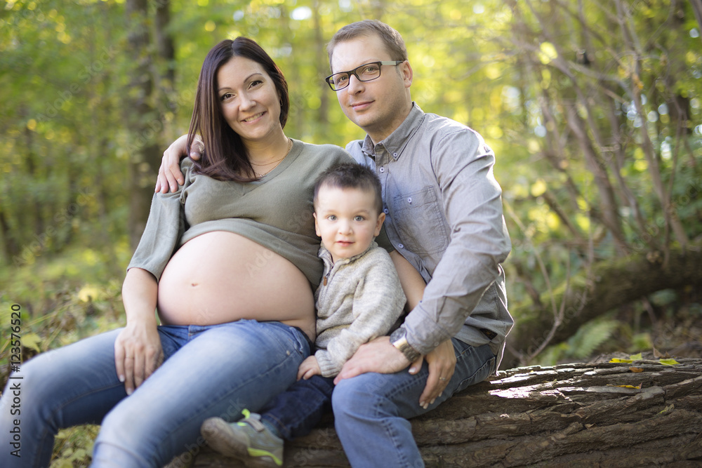 Happy pregnant family having fun in autumn nature Happy pregnant family having fun in autumn nature