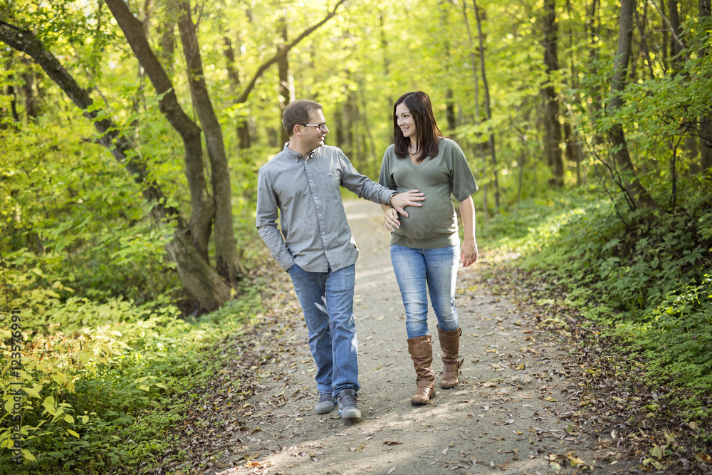 Beautiful pregnant couple relaxing outside in the park. Beautiful pregnant couple relaxing outside in the park.