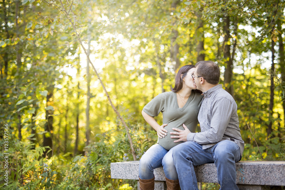 Beautiful pregnant couple relaxing outside in the park. Beautiful pregnant couple relaxing outside in the park.