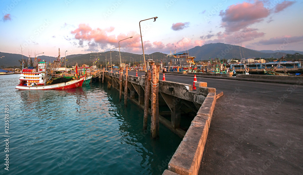 Fototapeta premium Landscape sea pier at sunset. The evening and the fishing boats reflecting in the dark water. Thailand, Koh Samui.