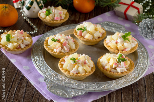 Holiday appetizer: tartlets with crab sticks, cheese and pineapp