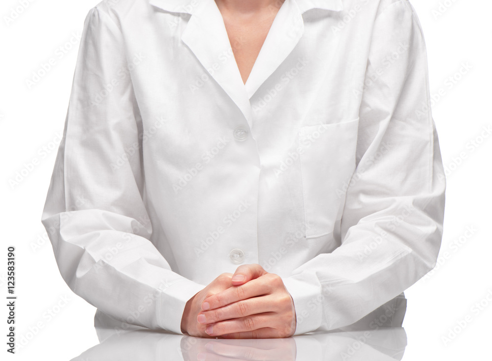 Female in white gown sitting at table against white background Female in white gown sitting at table against white background