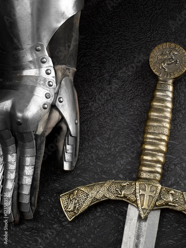 The iron glove of a knight and a sword.