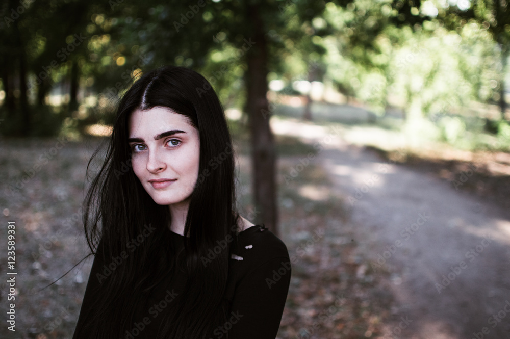 Outdoors portrait of beautiful young brunette woman looking at camera Outdoors portrait of beautiful young brunette woman looking at camera