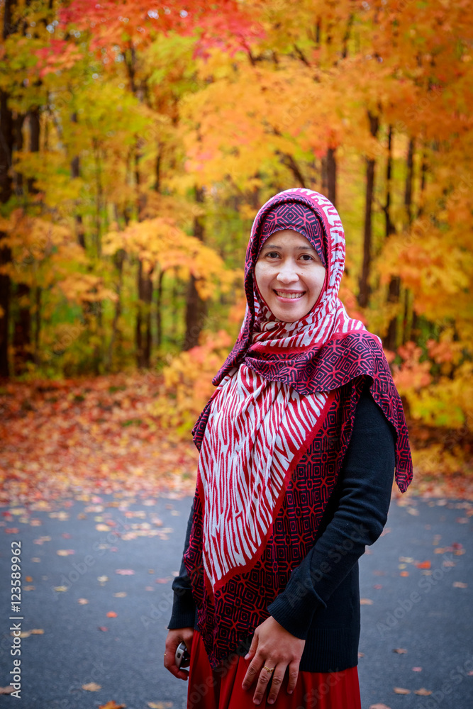 Muslim woman in Canada during autumn with colorful maple leaf as background Muslim woman in Canada during autumn with colorful maple leaf as background